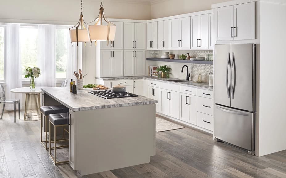 Modern kitchen interior with white cabinetry, stainless steel appliances, and a marble countertop island.
