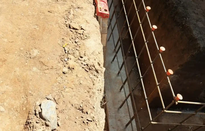 Close-up view of metal rebar grid structure in an excavation for home foundation construction