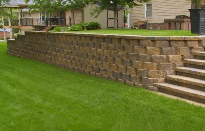 Terraced retaining wall made of beige-colored blocks on a manicured lawn