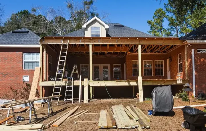 House under construction with wooden framework and exposed beams - house addition contractors