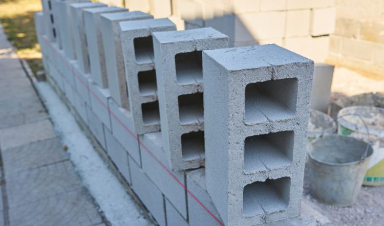 Row of gray concrete blocks with a red string line for alignment